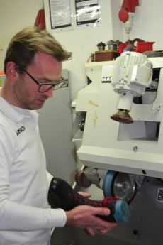 Orthopädieschuhtechniker bei der Arbeit an der Schleifmaschine in der Werkstatt